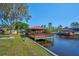 Picturesque view of a private dock with red roof and stunning water views at 6589 Banyan Dr, Indian Lake Estates, FL 33855