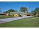 Beautiful yellow home with a long driveway and well-maintained green lawn at 6589 Banyan Dr, Indian Lake Estates, FL 33855