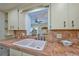 Close-up of the kitchen sink area with classic tile countertops and cabinetry at 6589 Banyan Dr, Indian Lake Estates, FL 33855