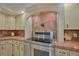 Modern stainless steel stove set against an archway of vintage tile backsplash in the kitchen at 6589 Banyan Dr, Indian Lake Estates, FL 33855