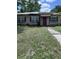 Modest single-story home with a pathway leading to a vibrant pink front door and windows with dark shutters at 1211 Ne 4Th St, Mulberry, FL 33860