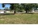 Green lawn with mature trees providing shade near homes, offering a pleasant neighborhood view at 1211 Ne 4Th St, Mulberry, FL 33860