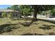 Street view of a home with mature trees and green grass, presenting a peaceful neighborhood setting at 1211 Ne 4Th St, Mulberry, FL 33860