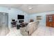Bright living room featuring tile floors, modern furniture, and an entertainment center with TV at 820 Lamp Post Ln, Lakeland, FL 33809
