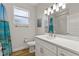 Well-lit bathroom with a white vanity, a window, and a shower with a blue patterned curtain at 5008 Ne 125Th Loop, Oxford, FL 34484