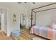 Bright bedroom with a four-poster bed, a sliding door mirrored closet and modern decor at 5008 Ne 125Th Loop, Oxford, FL 34484