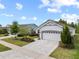 Beautiful single-story home featuring a charming facade, well-manicured landscaping, and a two-car garage at 5008 Ne 125Th Loop, Oxford, FL 34484
