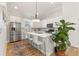 Bright kitchen featuring stainless steel appliances, an island with seating, and a stylish overhead light fixture at 5008 Ne 125Th Loop, Oxford, FL 34484