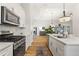 Modern kitchen boasts white cabinets, a stainless steel sink, and a gas range at 5008 Ne 125Th Loop, Oxford, FL 34484