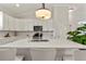 A well-lit kitchen features an island with seating, light countertops, and a full suite of appliances at 5008 Ne 125Th Loop, Oxford, FL 34484
