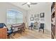 Cozy home office with a large window, a ceiling fan, and wood laminate flooring at 5008 Ne 125Th Loop, Oxford, FL 34484