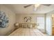 Bright bedroom with modern ceiling fan, wood floor, decorative painting and ensuite bathroom access at 1628 Saddlehorn Dr, Lakeland, FL 33810
