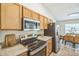 Kitchen view featuring stainless steel appliances, stone countertops, and open access to the dining area at 1628 Saddlehorn Dr, Lakeland, FL 33810