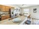 Kitchen view featuring stainless steel appliances, stone countertops, a double sink, and a bright dining area at 1628 Saddlehorn Dr, Lakeland, FL 33810