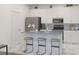 Modern kitchen featuring white cabinetry, stainless steel appliances, an island with stools, and elegant finishes at 1925 Fulfillment Dr, Kissimmee, FL 34744