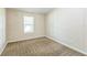 This bedroom features neutral carpet and paint and a window with a view to the outdoors at 4844 Creek Meadow Trl, Lakeland, FL 33810