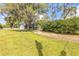 Landscaped front yard features a lush lawn and mature trees that provide shade for the home and add to its curb appeal at 4844 Creek Meadow Trl, Lakeland, FL 33810