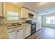 White cabinets, stainless steel sink, stone countertops, and views to the dining area define this kitchen space at 4844 Creek Meadow Trl, Lakeland, FL 33810