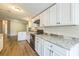 Well-lit kitchen features all white cabinetry, black oven and range, and light grey countertops with stone backsplash at 4844 Creek Meadow Trl, Lakeland, FL 33810