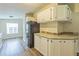 A refrigerator stands alongside white cabinetry and stone countertops in this view of the kitchen area at 4844 Creek Meadow Trl, Lakeland, FL 33810