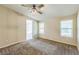 The main bedroom features a ceiling fan, neutral carpet and paint, and a doorway to the bathroom at 4844 Creek Meadow Trl, Lakeland, FL 33810