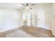 This main bedroom offers neutral carpet and paint, a ceiling fan, and doors to the bathroom and closet at 4844 Creek Meadow Trl, Lakeland, FL 33810