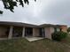 Back exterior with covered lanai, fenced yard, and solar panels at 1500 Fort Meade Pl, Poinciana, FL 34759