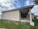 Exterior of home's rear with concrete patio and lawn leading to fenced yard at 1500 Fort Meade Pl, Poinciana, FL 34759
