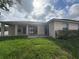 Exterior of home's rear with concrete patio and lawn at 1500 Fort Meade Pl, Poinciana, FL 34759