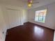 Bedroom with ceiling fan, double-door closet, window, and wood floors at 1500 Fort Meade Pl, Poinciana, FL 34759