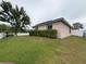 Back exterior view with lanai, fenced yard, and lush landscaping at 1500 Fort Meade Pl, Poinciana, FL 34759