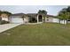 Charming single-story home featuring a two-car garage, palm trees, and well-maintained landscaping at 1500 Fort Meade Pl, Poinciana, FL 34759