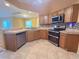 Well-equipped kitchen with stainless steel appliances, tile countertops, and mosaic backsplash at 1500 Fort Meade Pl, Poinciana, FL 34759