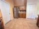 Bright kitchen with stainless steel refrigerator, tile floors, and white pantry doors at 1500 Fort Meade Pl, Poinciana, FL 34759