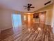 Open-concept living area with wood floors, fan, and sliding glass doors for plenty of sunlight at 1500 Fort Meade Pl, Poinciana, FL 34759