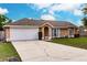 Charming single-story home with a two-car garage, well-maintained lawn, and inviting curb appeal at 206 Chris Ct, Davenport, FL 33896