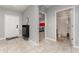 Well-lit hallway featuring tile floors, a shoe rack, with doorways to a bedroom and bathroom at 1336 Madison Cir, Haines City, FL 33844