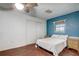 Bedroom with a unique blue accent wall, ceiling fan, and closet with wooden floors at 430 Alturas Babson Park Cutoff, Lake Wales, FL 33859