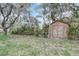 Backyard shed surrounded by mature trees and lush greenery at 430 Alturas Babson Park Cutoff, Lake Wales, FL 33859