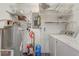 Functional utility room with washer, dryer, water heater, and ample wire shelving for organized storage at 430 Alturas Babson Park Cutoff, Lake Wales, FL 33859