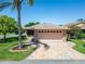 Charming home featuring a two-car garage and patterned brick driveway, surrounded by lush landscaping at 622 Jamaica Cir, Lakeland, FL 33803