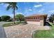 Two-car garage with brick siding and patterned brick driveway, surrounded by grass and landscaping at 622 Jamaica Cir, Lakeland, FL 33803