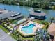 Aerial view of a community pool, shuffleboard court, and a building on the water with fountain views at 622 Jamaica Cir, Lakeland, FL 33803
