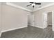 Spacious bedroom with crown molding, gray floors, ceiling fan, and multiple doorways at 7717 Somersworth Dr, Kissimmee, FL 34747