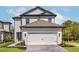 Beautiful two-story home with an attached two-car garage and well manicured lawn at 7717 Somersworth Dr, Kissimmee, FL 34747