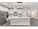 Modern kitchen featuring white cabinets, stainless steel appliances, and a large center island at 7717 Somersworth Dr, Kissimmee, FL 34747