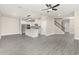Open-concept living area with gray floors, a modern kitchen, and a staircase at 7717 Somersworth Dr, Kissimmee, FL 34747