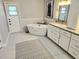 Bright and airy bathroom featuring a standalone soaking tub, double vanity, and modern finishes at 8212 Borgia Ct, Orlando, FL 32836