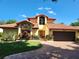 Charming home featuring a red tile roof, brick driveway, manicured lawn and lush landscaping at 8212 Borgia Ct, Orlando, FL 32836
