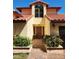 Inviting front entrance featuring a brick walkway, arched windows, and manicured bushes at 8212 Borgia Ct, Orlando, FL 32836